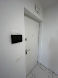 a white room with a door with a television on it at Renewed 2 Bedroom Apartment with Parking in Ljubljana