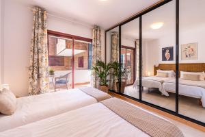 a bedroom with two beds and a balcony at VILOS LAS CANTERAS in Las Palmas de Gran Canaria