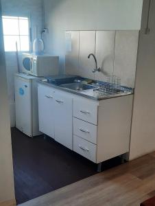 uma cozinha com um lavatório e um micro-ondas em Confortable apartamento-monoambiente en Mercedes em Mercedes