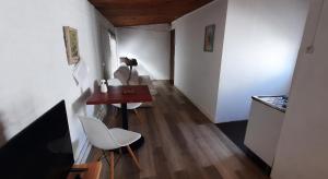 Confortable apartamento-monoambiente en Mercedes في مرسيدس: ممر مع طاولة وكراسي في غرفة