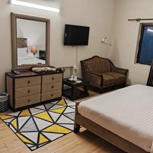 a bedroom with a bed and a mirror and a chair at Infinity Villa in Islamabad