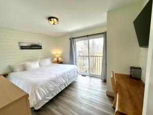 1 dormitorio con cama blanca y ventana grande en Hike BIke Chill, en Collingwood