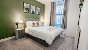 - une chambre avec un grand lit et une fenêtre dans l'établissement Eden Apartments, à Bridlington