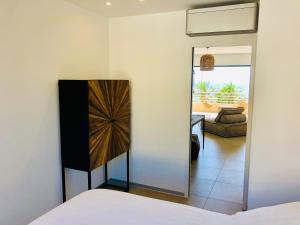 un dormitorio con una cama y un espejo en Appartement T3 lumineux traversant totalement neuf en face de la plage Front de mer vue sur les iles Vue mer panoramique assurée Résidence de la plage centre ville du Lavandou 3eme étage avec ascenseur Appartement T3, en Le Lavandou