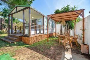 a house with a porch and a table and chairs at Bungalow Cádiz Costa in Chiclana de la Frontera