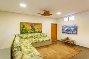 a living room with a couch and a ceiling fan at Anacã Ecolounge in Bonito