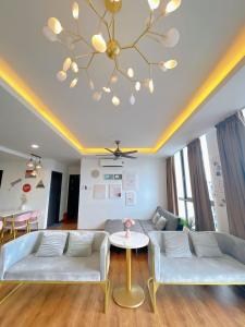 een woonkamer met een bank en een kroonluchter bij Vivacity Apartment Kuching Jazz 2 125 in Kuching