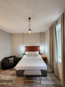 een slaapkamer met een groot bed en een bank bij Hotel Amfiteatar in Pula