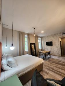 een slaapkamer met een groot bed en een tafel bij Hotel Amfiteatar in Pula