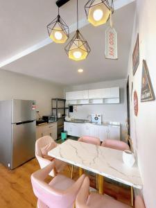 een keuken met een tafel en roze stoelen in een kamer bij Vivacity Apartment Kuching Jazz 2 125 in Kuching