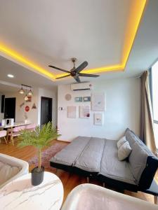 een woonkamer met een bank en een plafondventilator bij Vivacity Apartment Kuching Jazz 2 125 in Kuching