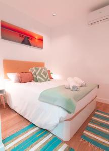 een slaapkamer met een groot wit bed en handdoeken bij EDomus Duque Boutique in Sevilla