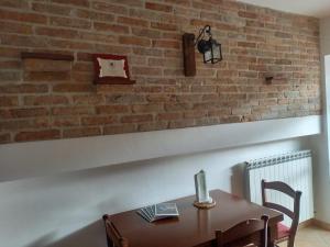 un comedor con una pared de ladrillo y una mesa en La Casa di Cardini, en San Giacomo