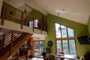 una sala de estar con paredes verdes y una escalera. en Whimsical Lakefront Chalet en Monticello