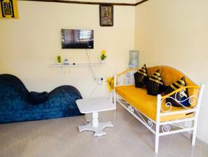 sala de estar con banco y TV en Pury Bnb's, en Marigat