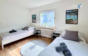 een slaapkamer met 2 bedden en een raam bij BEGE APARTMENTS Business Residence in Hagen