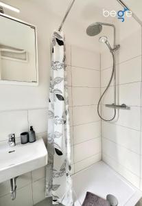 een badkamer met een douche en een wastafel bij BEGE APARTMENTS Business Residence in Hagen