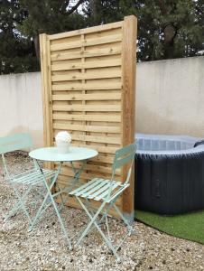 une table et deux chaises à côté d'une clôture dans l'établissement Chambre d'amour, à Villeneuve-lès-Avignon