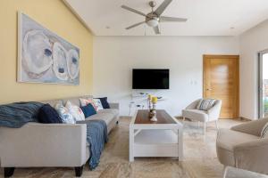 a living room with a couch and a tv at Apartamento en Residencial Jardines de Monserrat in Las Terrenas