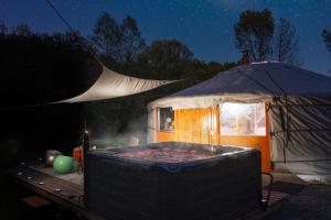 a gazebo with a hot tub and a tent at L ost in Sensations -Hébergements Insolites et Suites de luxe Spa Sauna Piscine Forêt in Marcenas