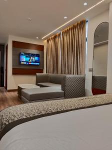 - un salon avec un canapé et une télévision dans l'établissement Western Blu INN, à New Delhi