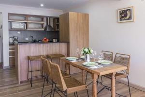 a kitchen and dining room with a wooden table and chairs at LA TUA CASA in San Carlos de Bariloche