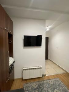 a living room with a tv on a white wall at Apartments & Rooms L E F T RIVER Belgrade in Belgrade
