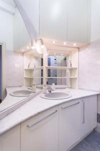ミラノにあるフラット イン ドゥオーモの白いバスルーム(シンク2台、鏡付)