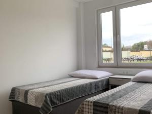 two beds in a room with a window at A cozy house close to the beach, azy in Łazy