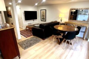 ein Wohnzimmer mit einem schwarzen Sofa und einem Tisch in der Unterkunft Stylish Deluxe 2BDR Guest Apartment in Hamilton