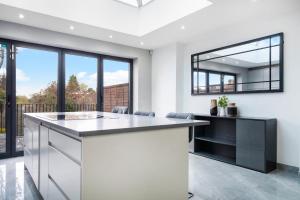 a kitchen with a large counter and a mirror at Hububb Luxury Eastcote in Eastcote