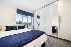 a bedroom with a large bed and a large window at Hububb Luxury Eastcote in Eastcote