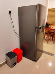 a stainless steel refrigerator in a kitchen with a table at A two bedroom luxury apartment at Canterbury Golf Resort in Kahatuduwa