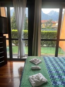 two towels on a bed in front of a window at B&B Resilienza in Lecco