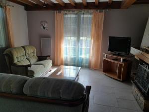 sala de estar con sofá y TV en Gîte du parc, en Pierre