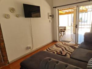 a living room with a couch and a flat screen tv at Home Sweet Home in Polokwane