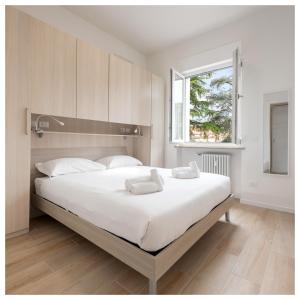 - un grand lit blanc dans une chambre avec fenêtre dans l'établissement Flats4rent Chiara, à Vérone