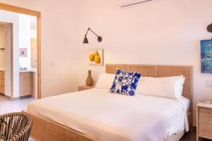 - une chambre dotée d'un grand lit blanc avec des oreillers bleus et blancs dans l'établissement Beachfront Retreat in Cerritos, à El Pescadero