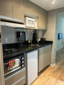a kitchen with a sink and a microwave at Ap Smart Hub in Campinas