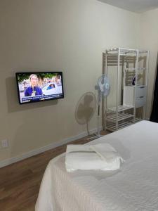 a bedroom with a bed with a tv on the wall at Ap Smart Hub in Campinas