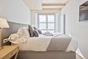 a bedroom with a white bed with a window at Luderna - Apartamento Val de Ruda A38 de Sanèla in Baqueira-Beret