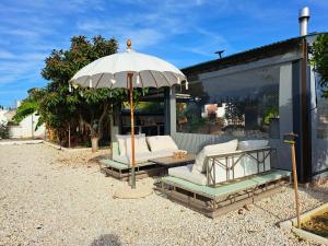 une terrasse avec un parasol, des chaises et une table dans l'établissement B&B Go Spain, à Alhaurín el Grande