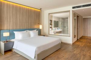a bedroom with a large white bed and a large window at À La Carte Halong Bay in Ha Long
