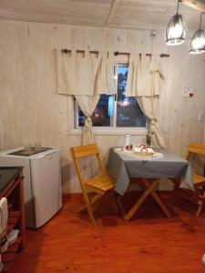 cocina con mesa, sillas y ventana en SanDo Uribe Cabañas Exclusivas solo adultos en Uribelarrea