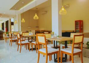 a restaurant with wooden tables and chairs and lights at Nord Luxxor Juazeiro do Norte in Juazeiro do Norte