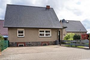 a house with a black roof and a driveway at Ferienwohnung Strempel in Templin