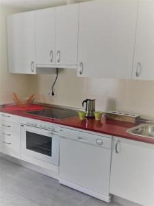 cocina con armarios blancos y encimera roja en Apartamento próximo Muralla Ávila by Alterhome en Ávila
