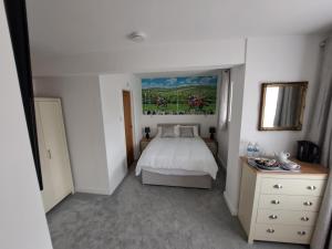 a bedroom with a bed and a painting on the wall at Westleigh House in Fishbourne