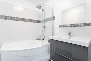 Baño blanco con aseo y lavamanos en Appartement proche du Vieux Lille avec une vue exceptionnelle sur la Ville !, en La Madeleine