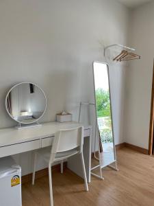 een wit bureau met een spiegel en een witte stoel bij Wantanee Ville วันทนีย์วิลล์ in Ban Wang Sai